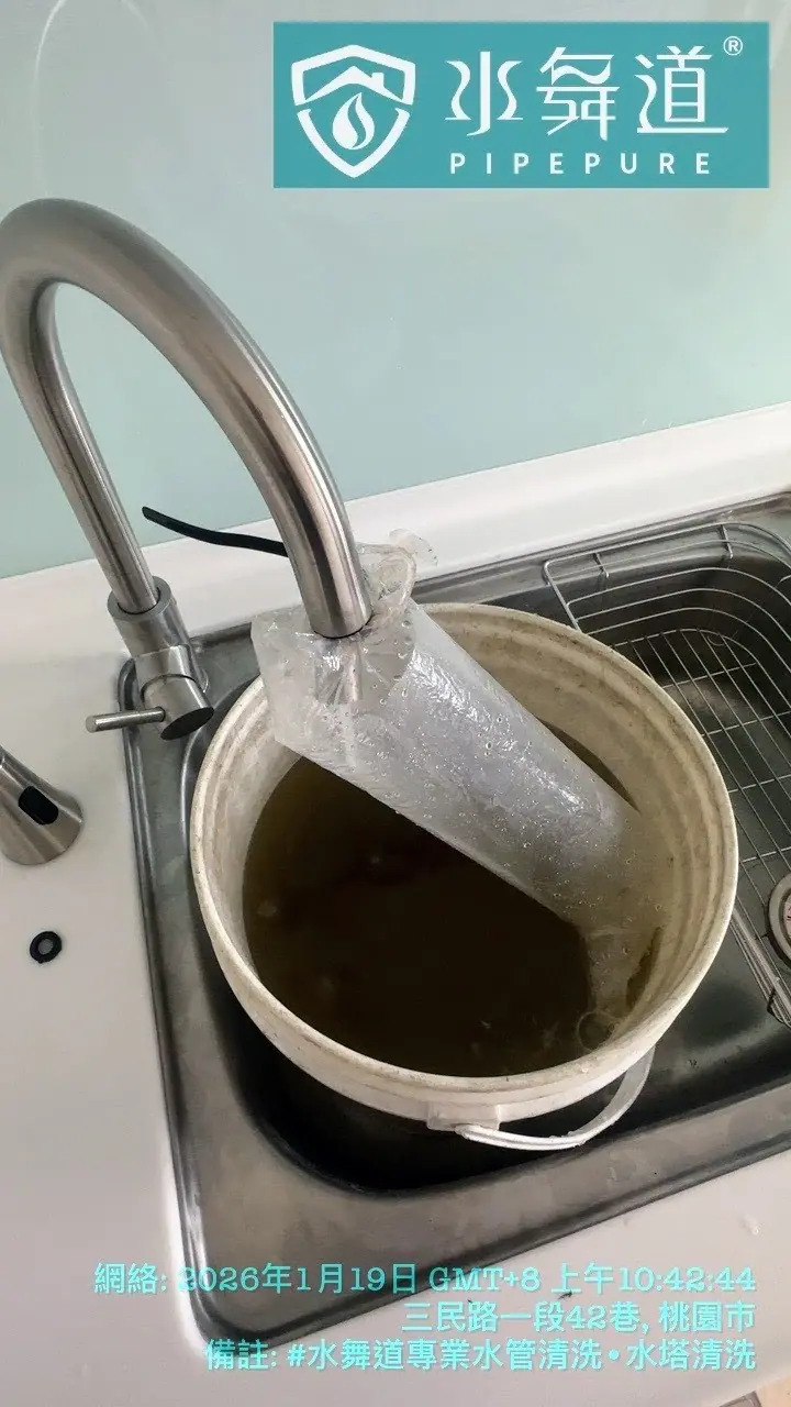 水槽中收集清洗過程中排出的深褐色沉積物,展示水管內鏽蝕物質的積累情況