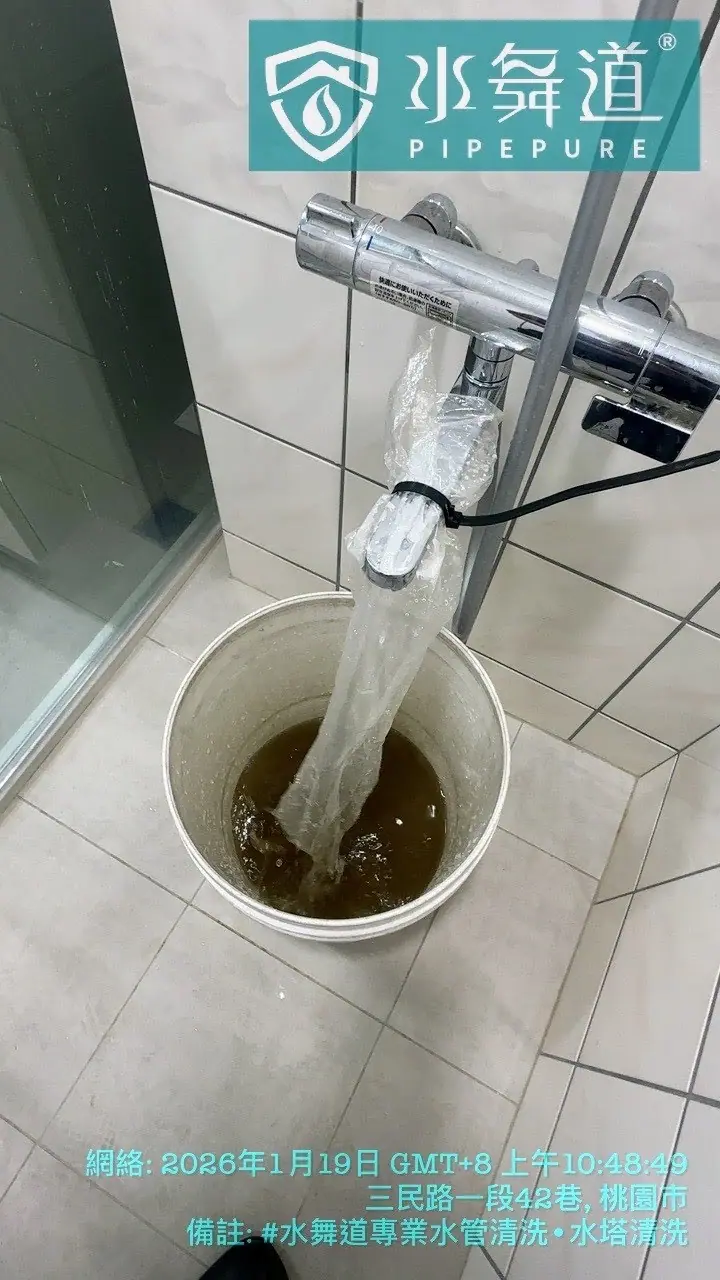 浴室淋浴管道清洗作業進行中,深褐色的排出水流經透明收集袋進入收集容器,展示管線內部鏽蝕物質的清洗過程