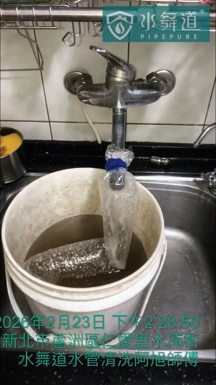 水管清洗過程中，從廚房水龍頭流出的混濁水流注入白色水桶，水中可見深褐色沉積物。