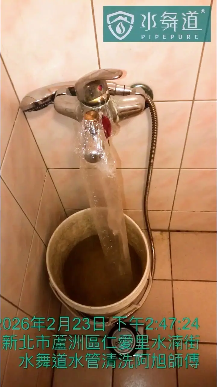 浴室內的蓮蓬頭軟管被接入白色水桶進行沖洗，桶內的水同樣呈現混濁的黃褐色。