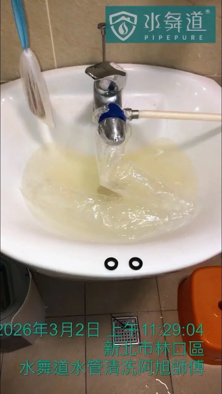 在水管清洗過程中，一個套在龍頭上的透明集水袋裝滿了淡黃色的混濁水