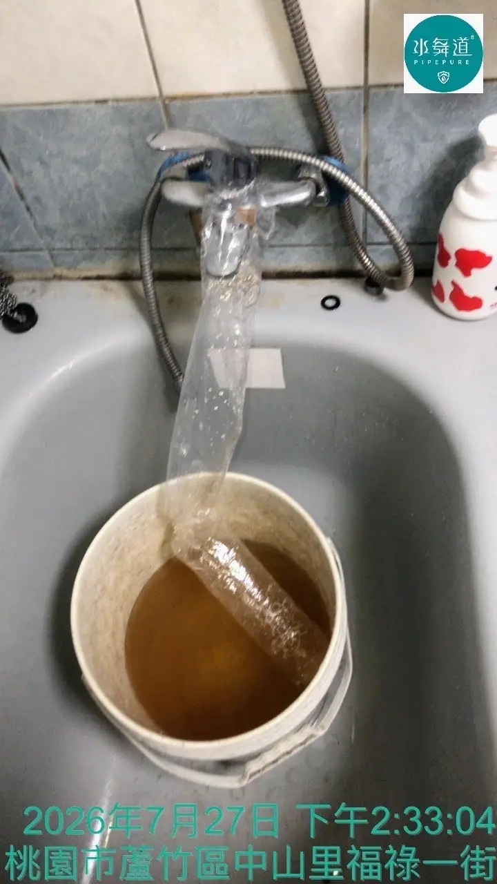桃園蘆竹27年大樓主臥浴室熱水管清洗，排出黃褐色沉積物施工畫面。